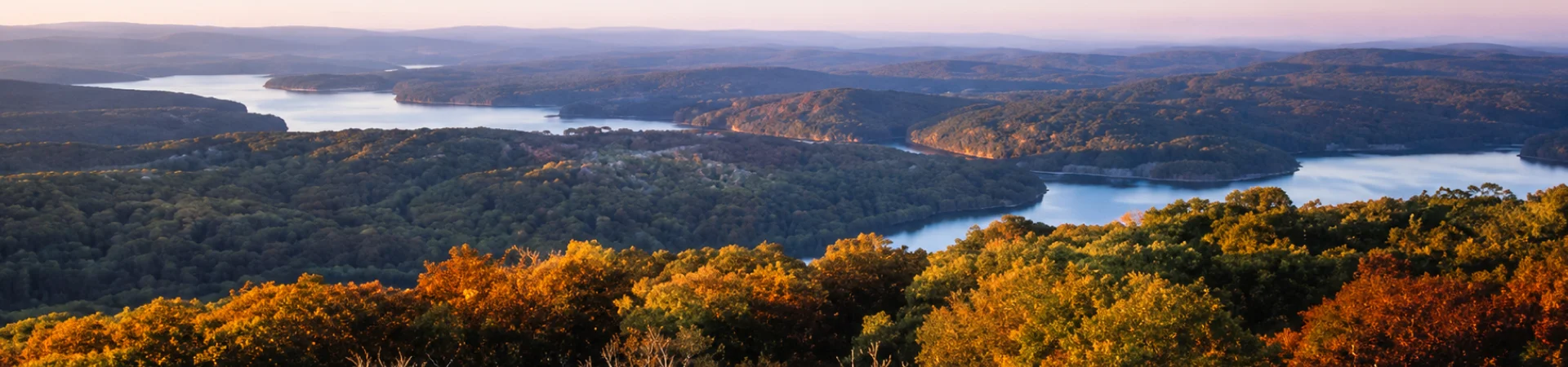 Aerial view of Deep Creek Lake surrounded by fall foliage at dusk