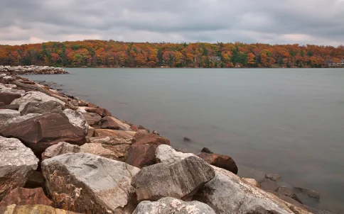 Jetty with fall foliage across the lake